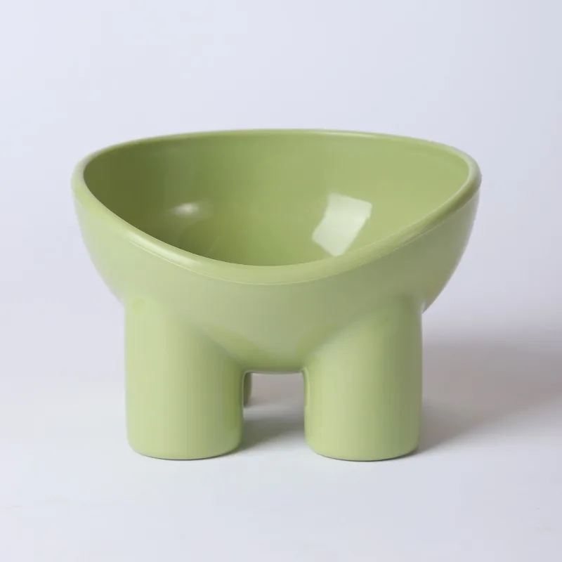 Green raised plastic bowl on four short legs, with a tilted rim