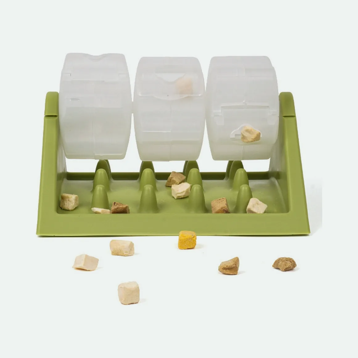 Green rotating treat feeder with three clear drums and kibble on the ridged base